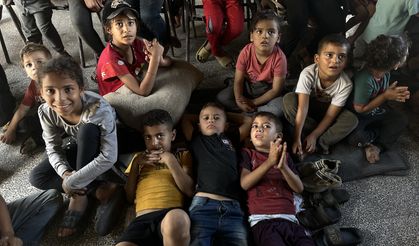 Filistinli gönüllü, yıkık binada çocuklara televizyon seyrettiriyor