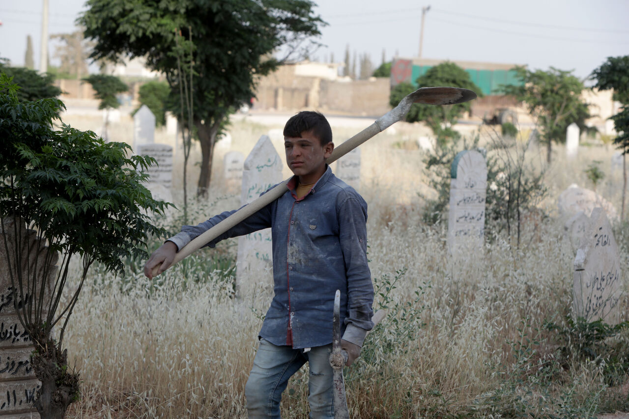 AA-20230613-31414085-31414081-SURIYE_ORDUSUNUN_YETIM_BIRAKTIGI_HALEPLI_COCUK_AILESINE_BAKABILMEK_ICIN_MEZAR_KAZIYOR